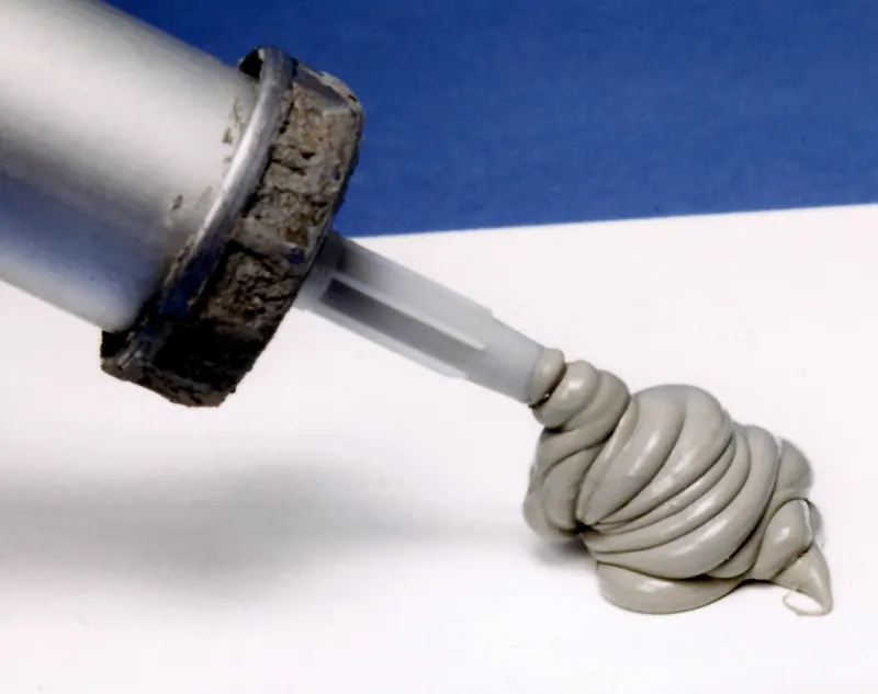 Cordon de mastic gris en sortie de cartouche